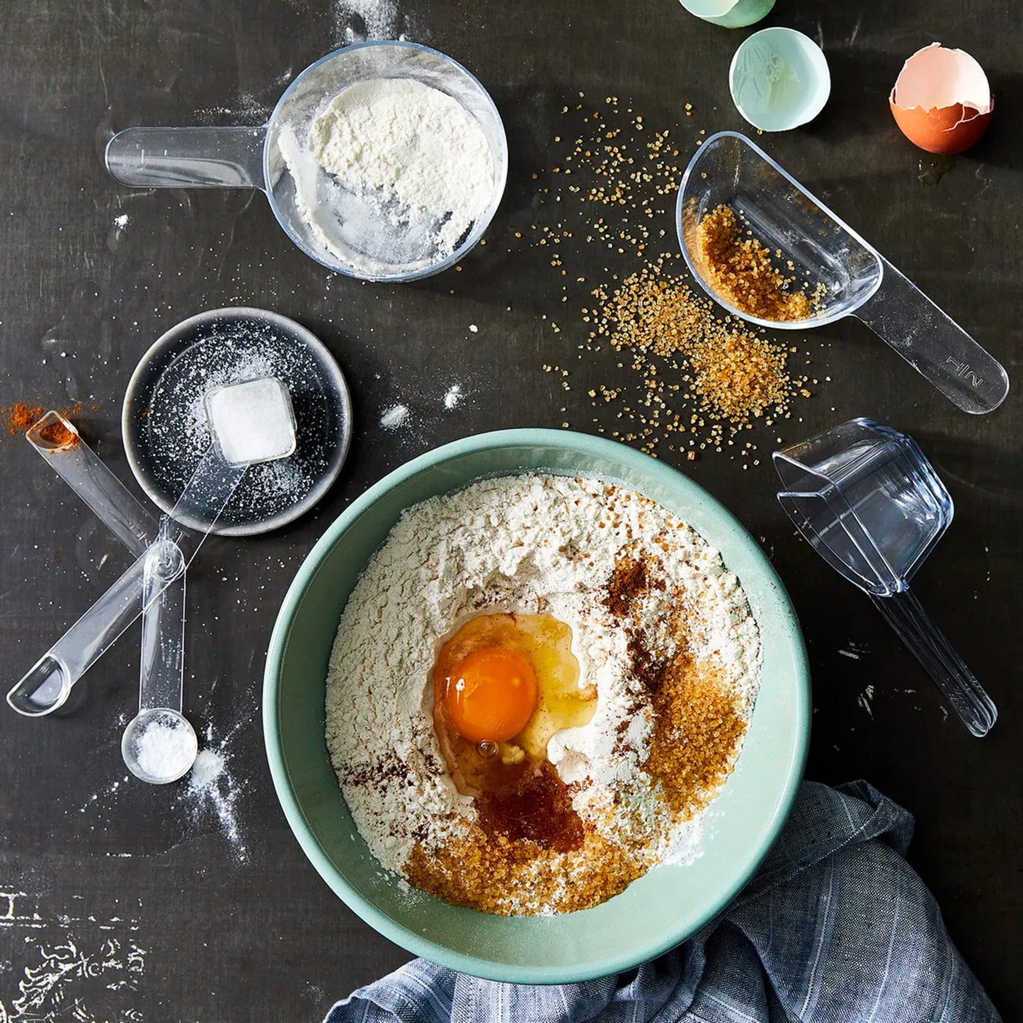 visual measuring cups and spoons shown on a messy kitchen countertop in use