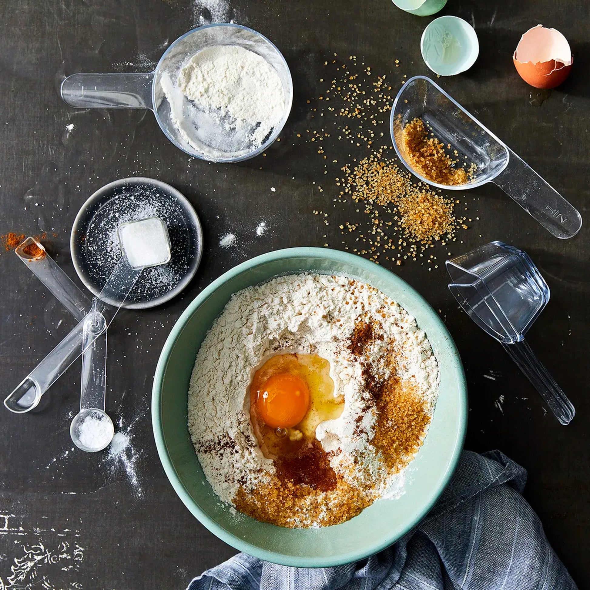 visual measuring cups and spoons shown on a messy kitchen countertop in use